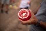 a close up of a person holding a pomegranate