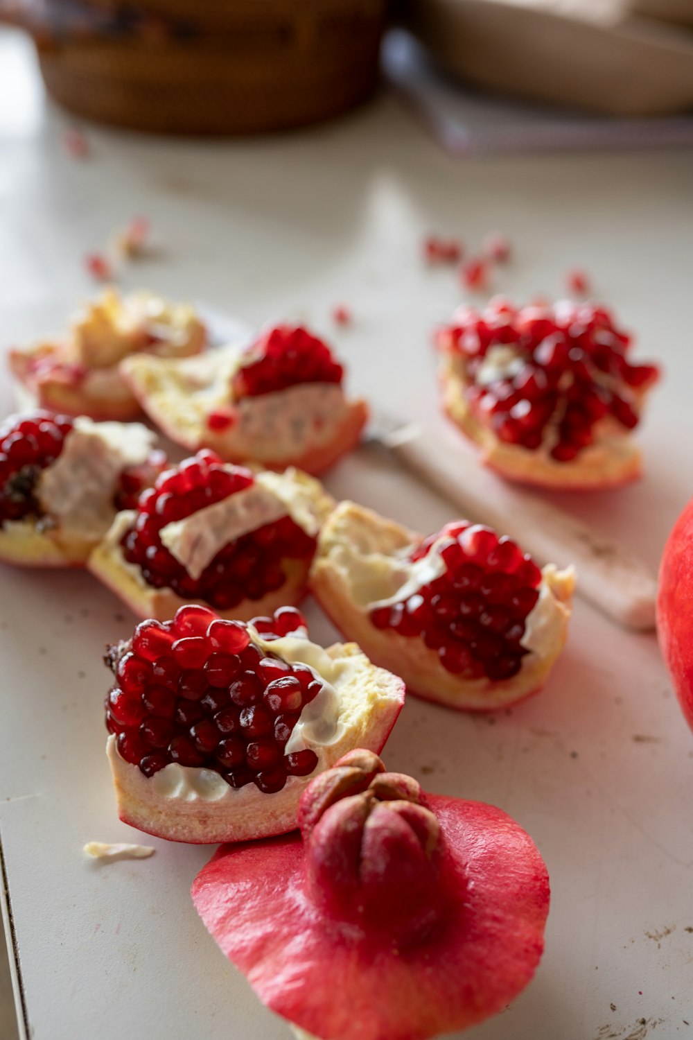 a table topped with pomegranates and a knife