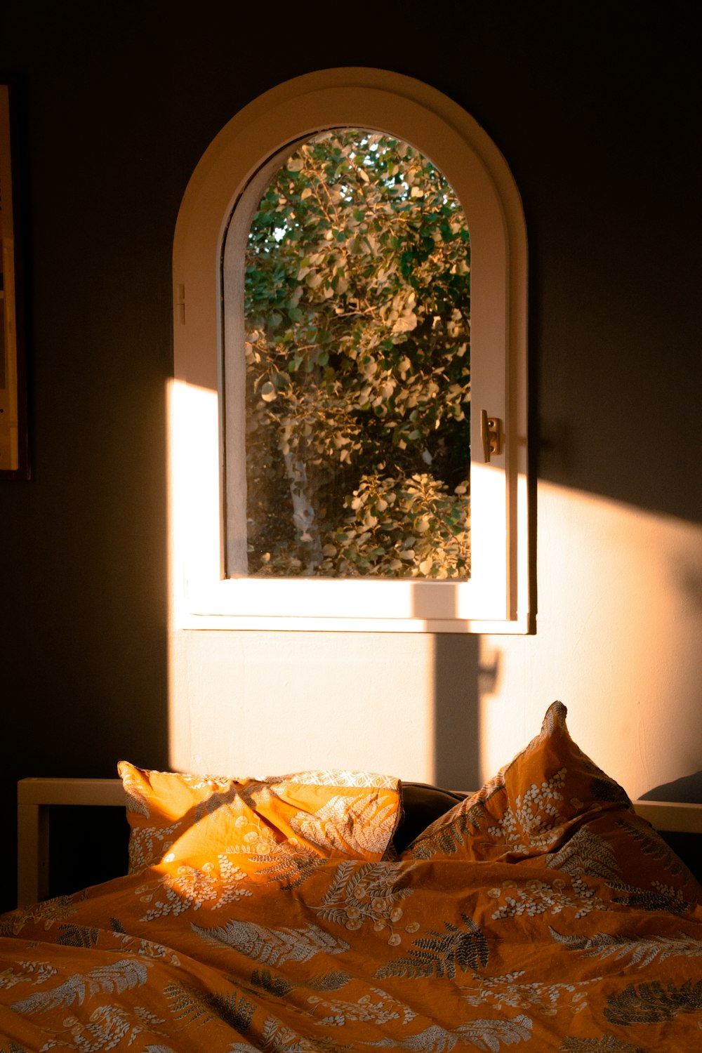 a bed with a yellow comforter and a window
