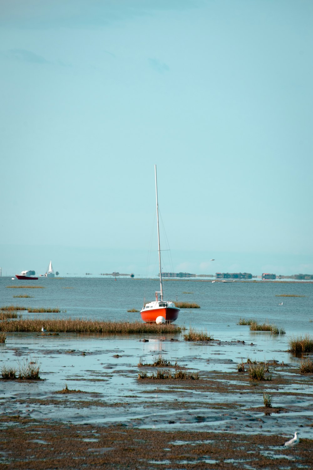 a small sailboat sitting on top of a body of water