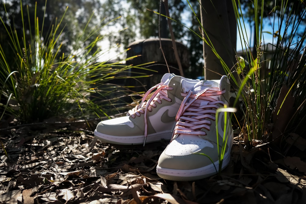 a pair of white sneakers with pink laces on them