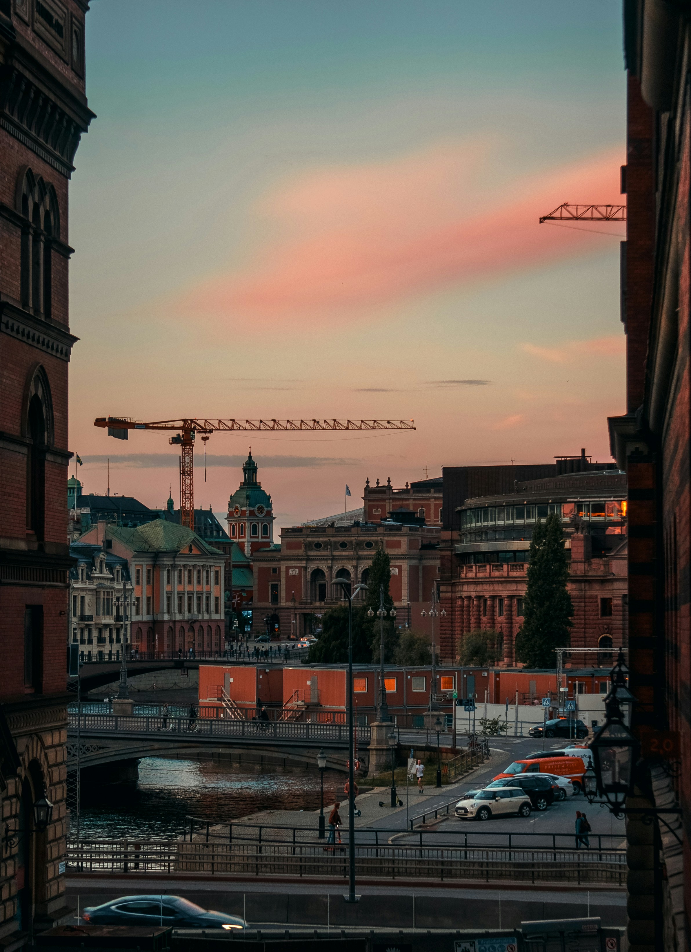 Una vista del atardecer de una ciudad con una grúa al fondo