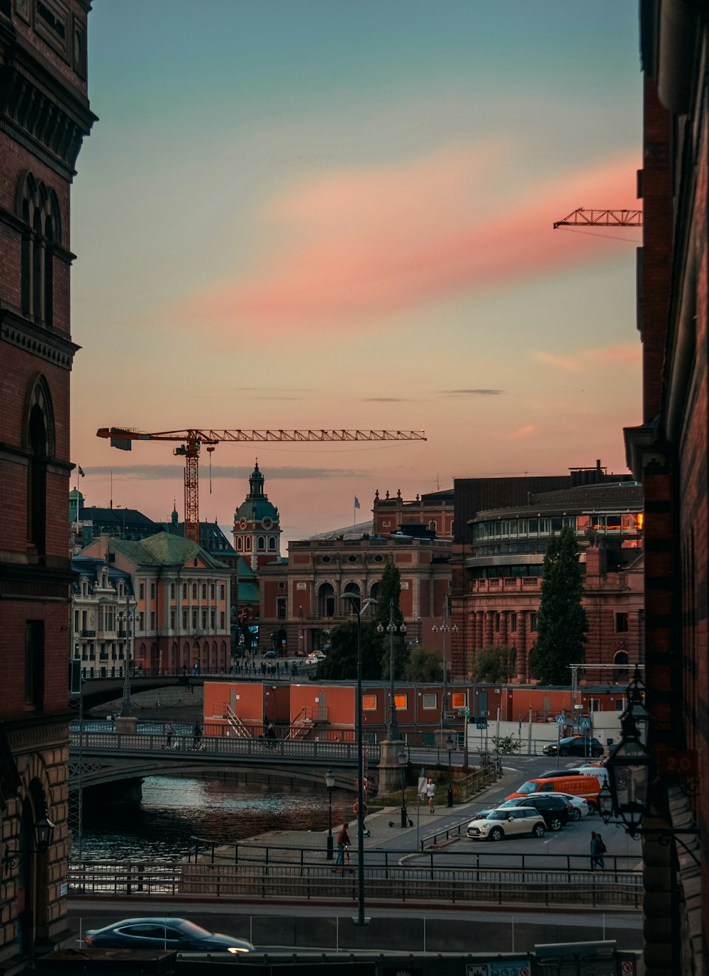 a sunset view of a city with a crane in the background