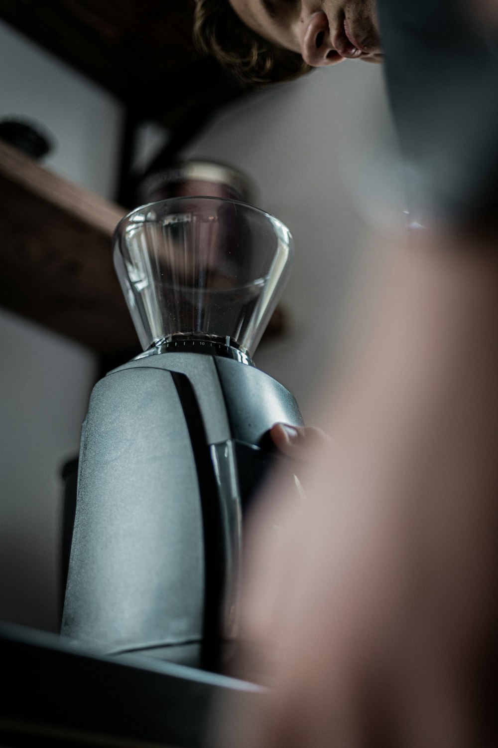 a woman is looking at a coffee maker