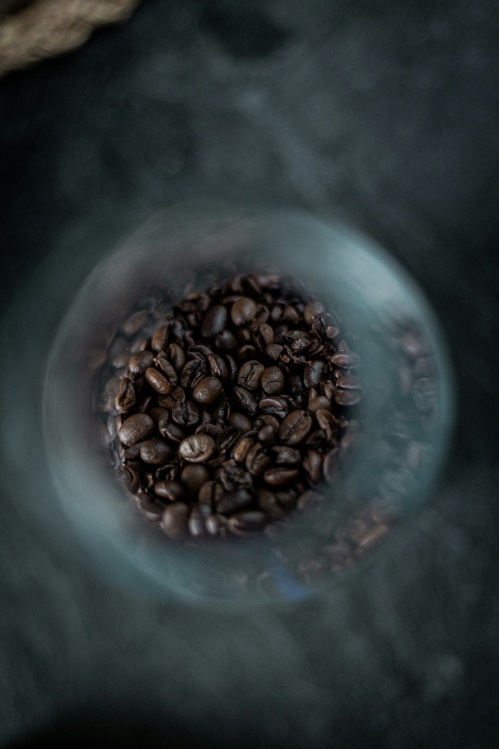 a glass bowl filled with coffee beans on top of a table