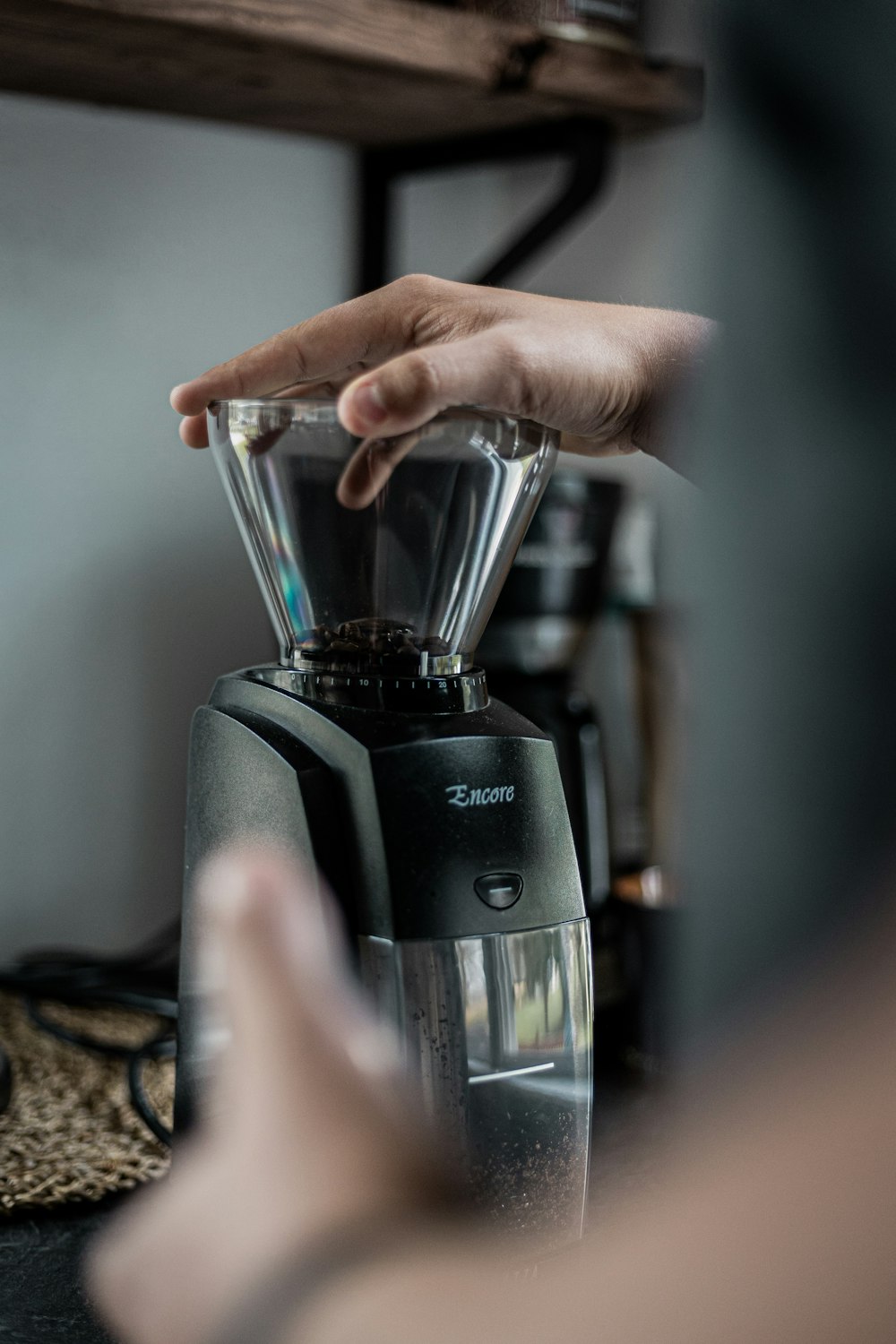 a person pressing buttons on a coffee maker