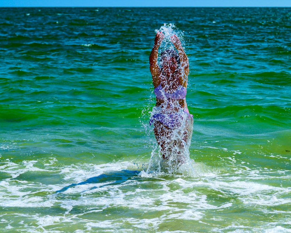 a person standing in the ocean splashing water