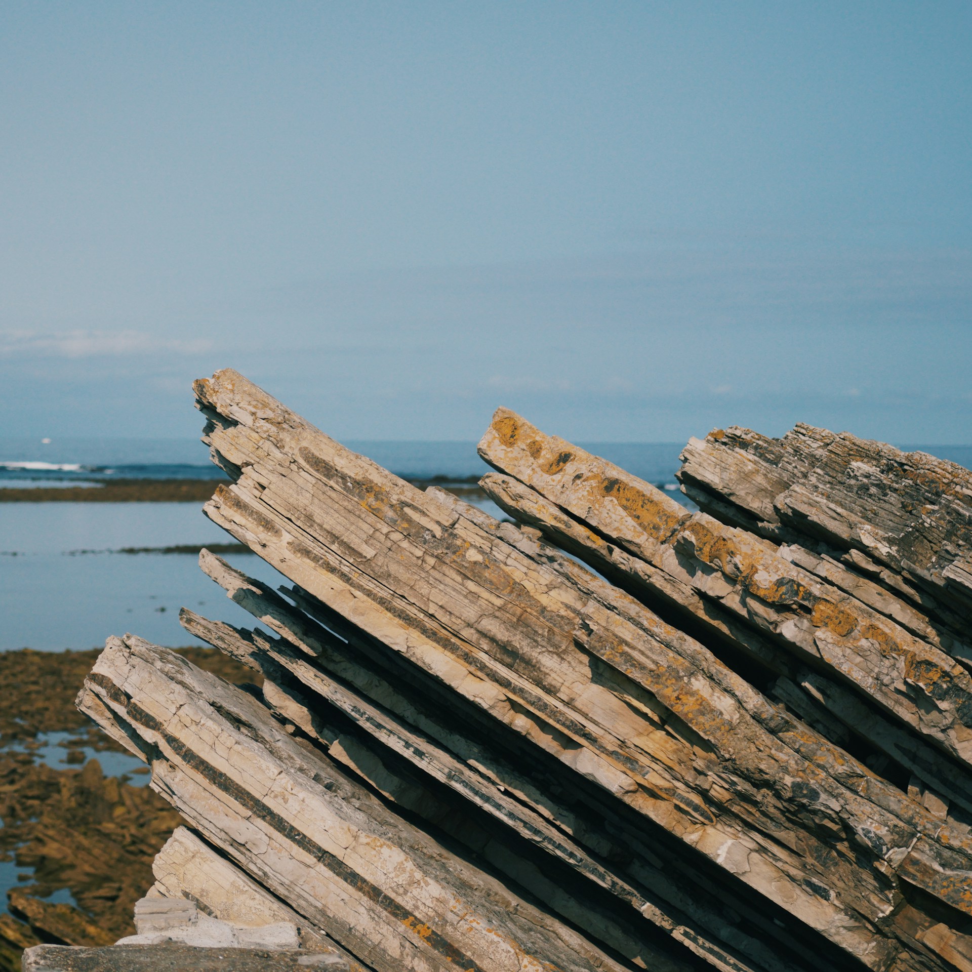 a pile of rocks sitting next to a body of water