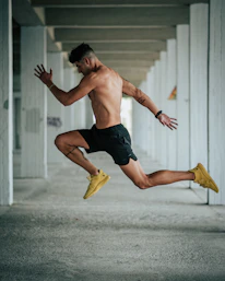 a shirtless man is jumping in the air