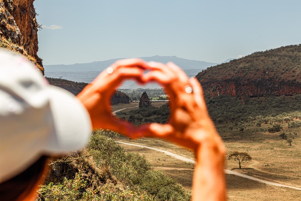 a person making a heart shape with their hands