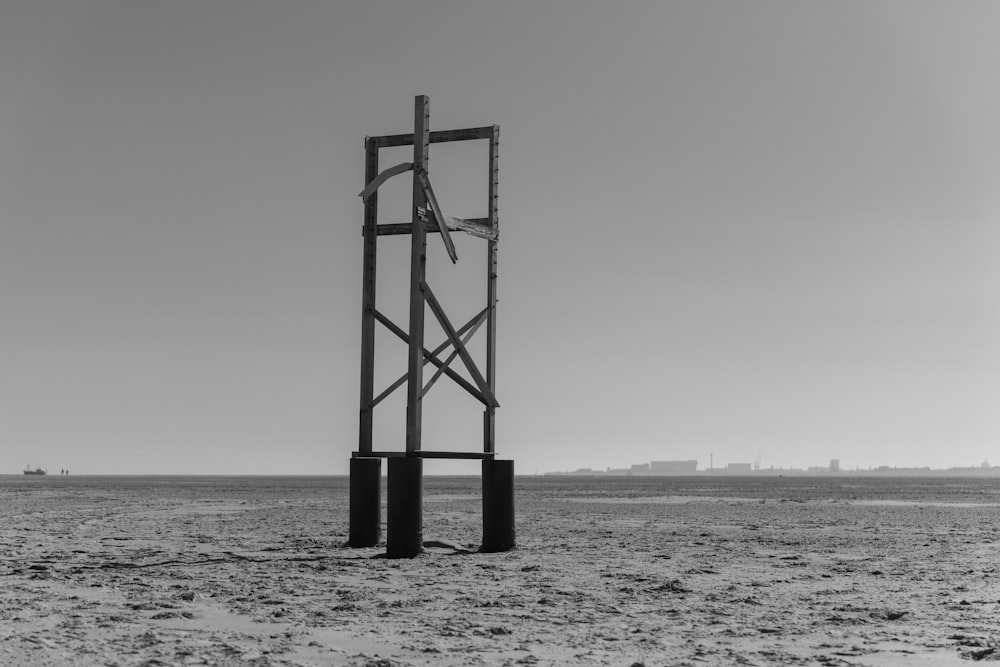 a tall metal structure sitting on top of a sandy beach