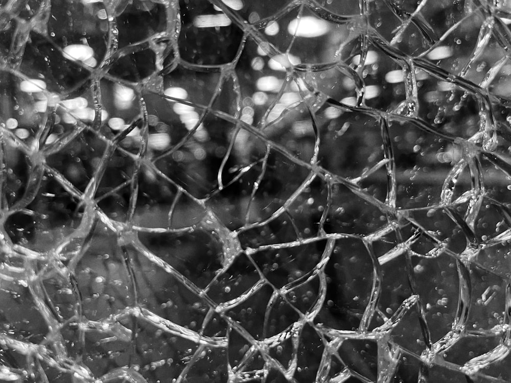 Une photo en noir et blanc d’une fenêtre brisée