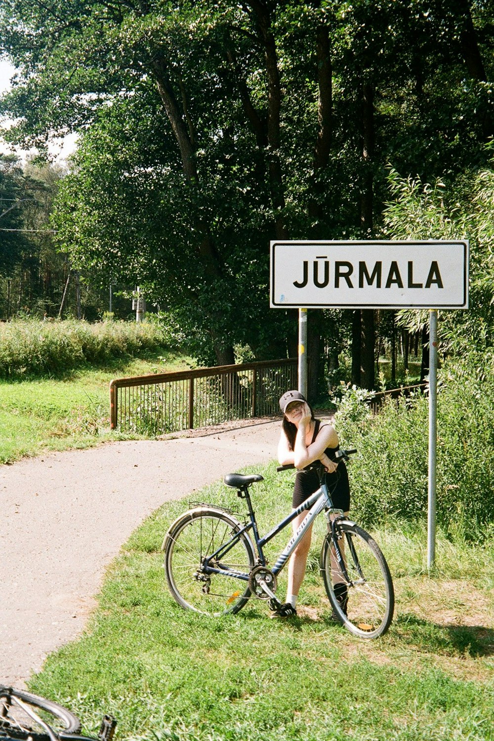 a woman sitting on a bike next to a sign