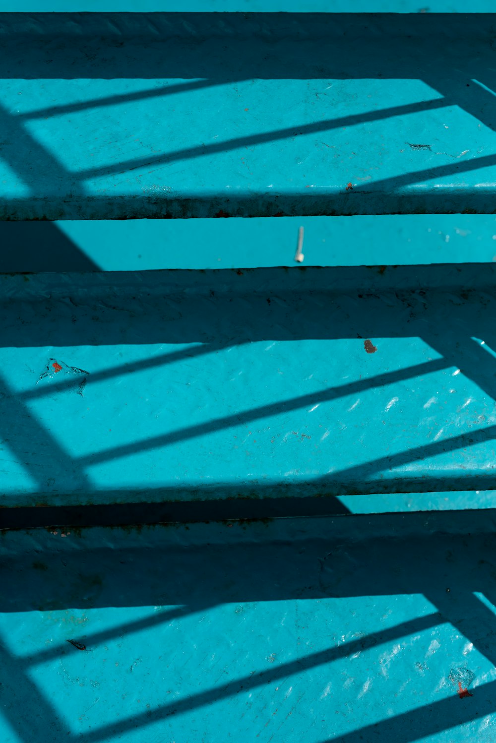 a close up of a bench with blue paint