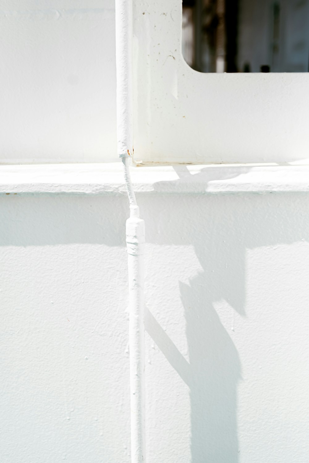 uma sombra de um sinal de rua em uma parede branca
