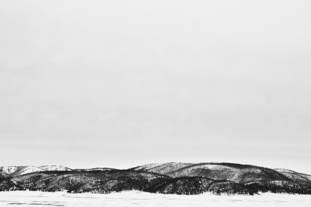 a black and white photo of a snowy mountain range