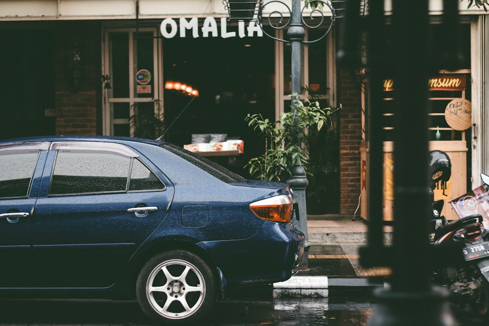 a blue car parked in front of a building