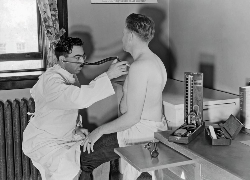 a black and white photo of a man brushing his teeth