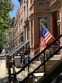 Charming brownstone townhouse with classic NYC stoop bathed in warm afternoon light.