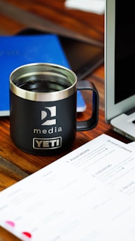 a coffee mug sitting on a desk next to a laptop