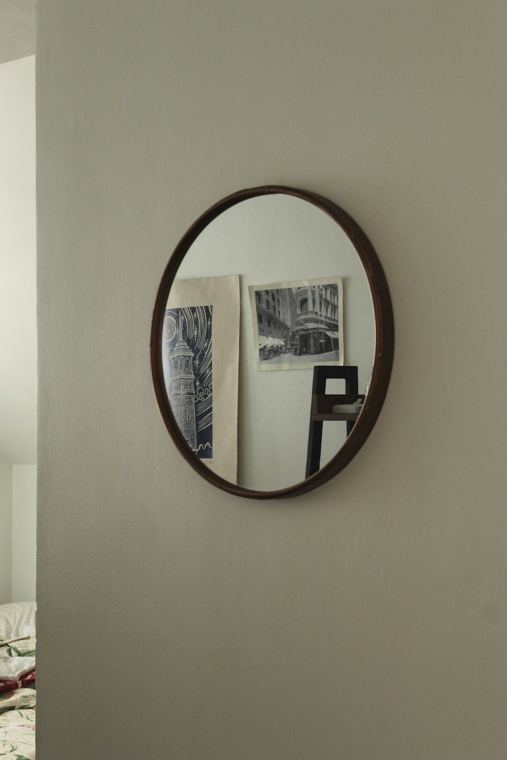 a round mirror hanging on the side of a wall