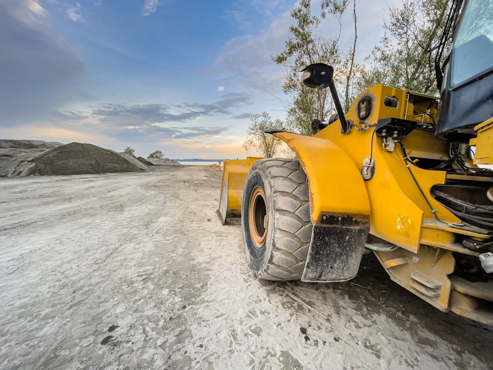 Un bulldozer giallo è parcheggiato su una strada sterrata