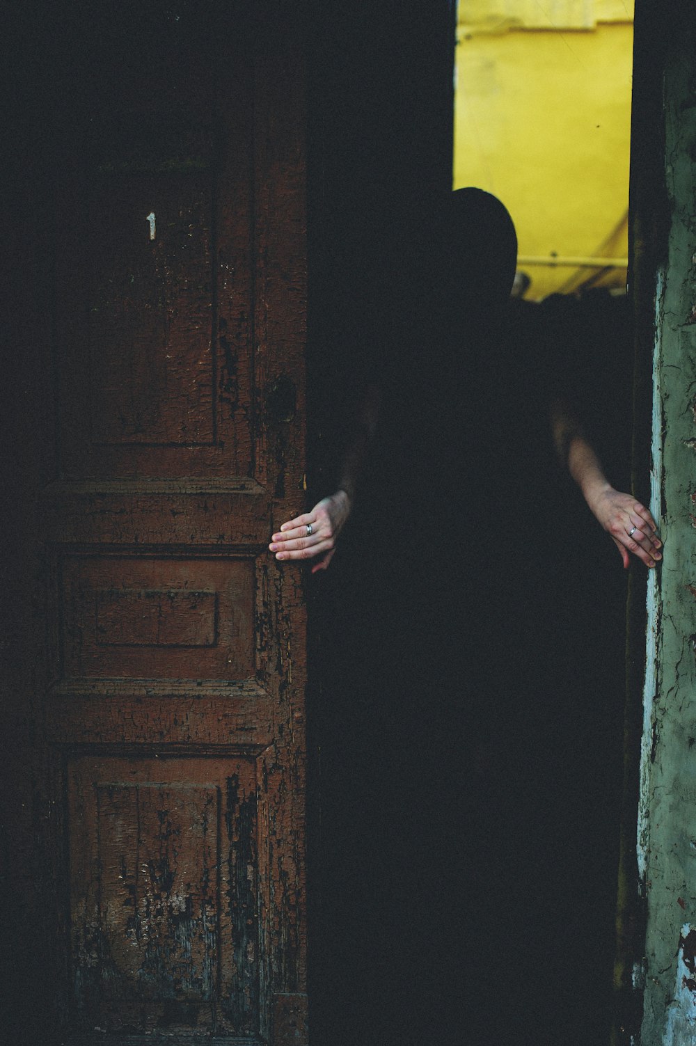 uma pessoa em um manto preto em pé na frente de uma porta