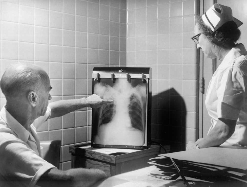 a man and a woman looking at a chest x - ray