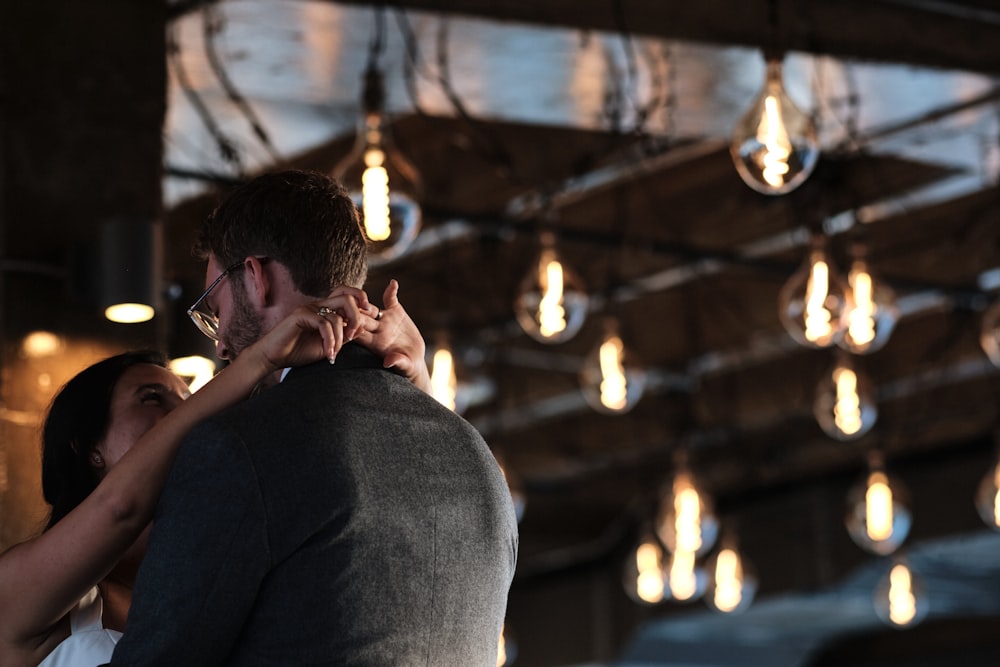 a man and a woman standing under a chandelier