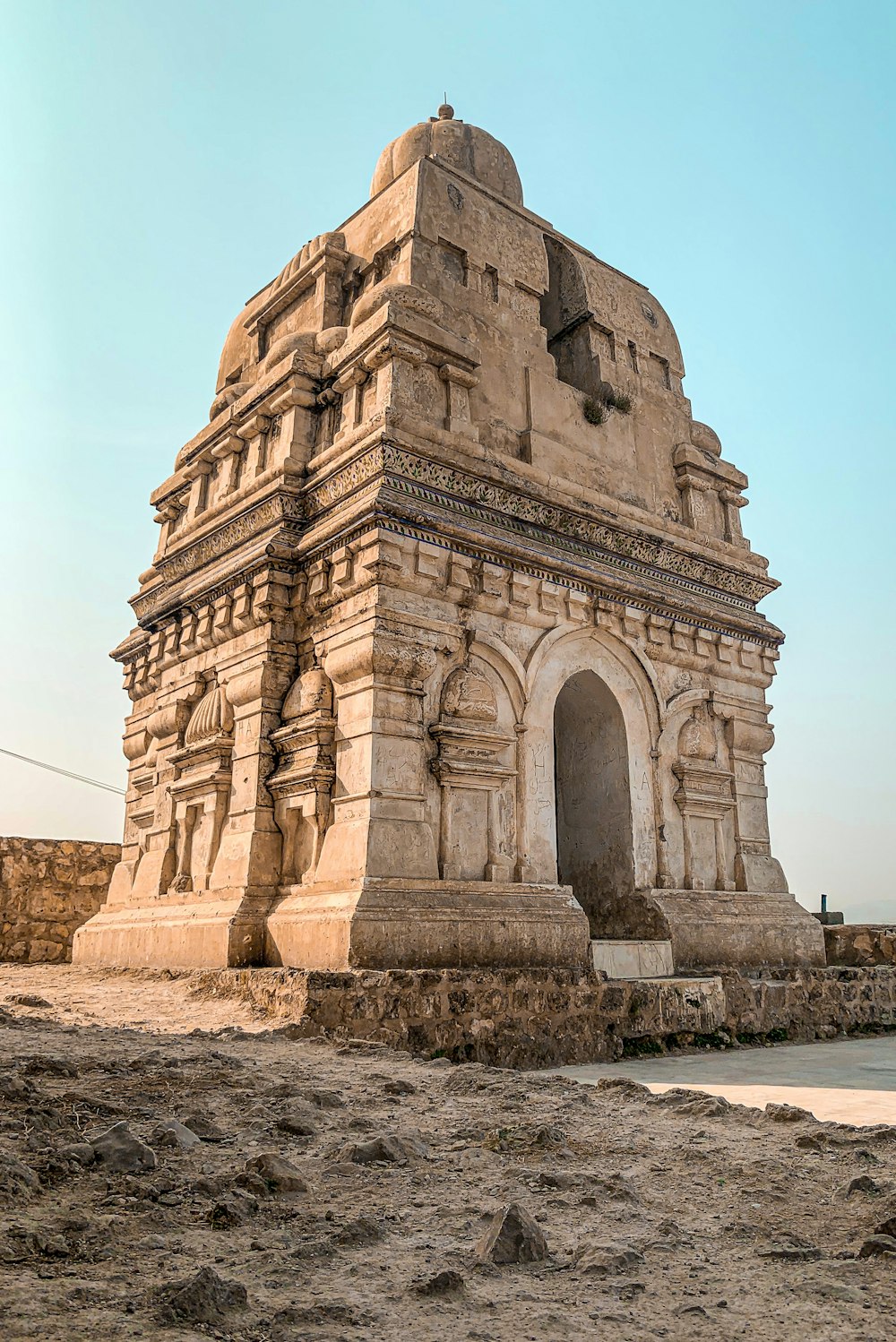 a large stone structure sitting on top of a dirt field