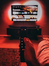 A family enjoying TV time together, easily switching channels using a mobile device.