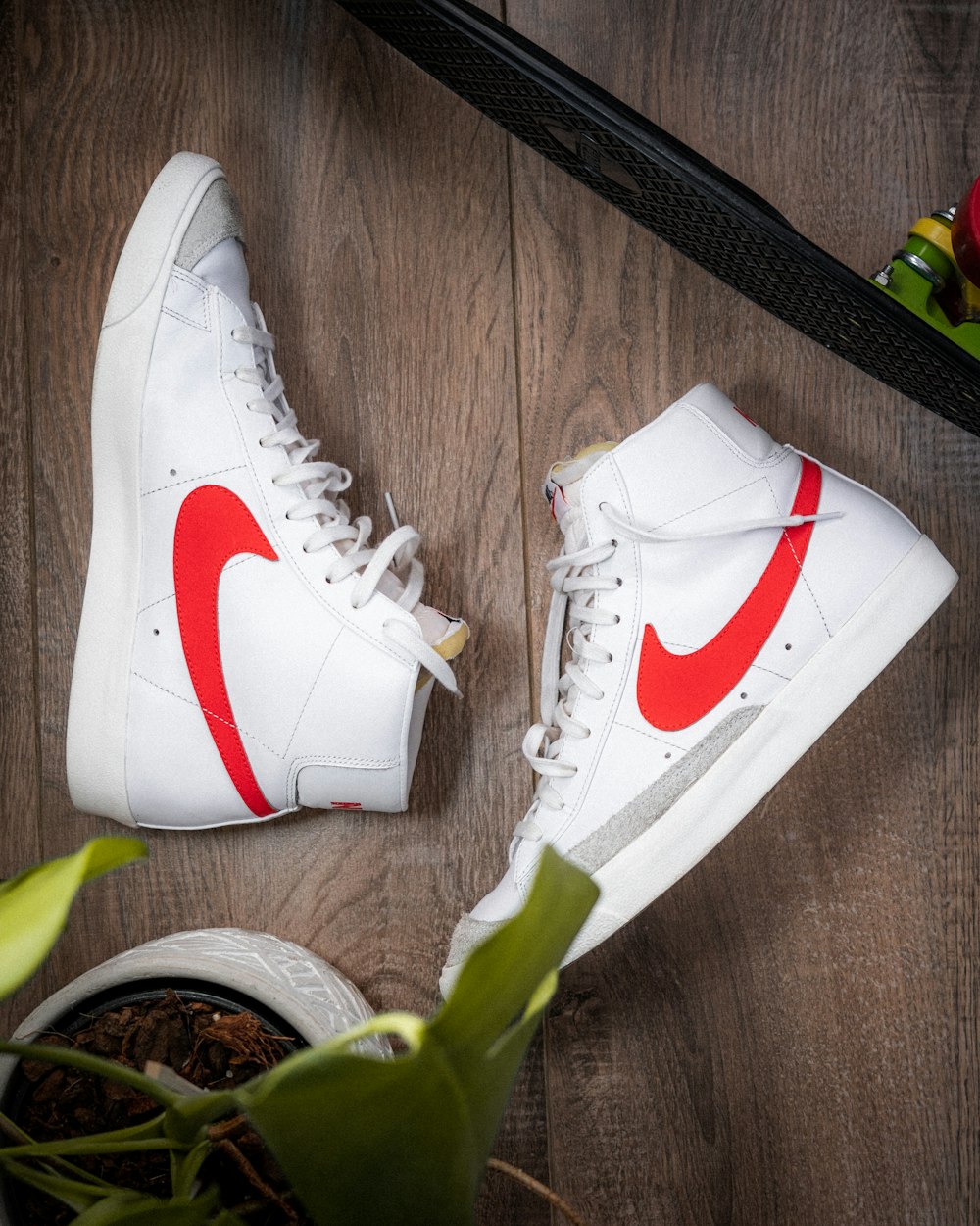 a pair of white sneakers with a red nike logo