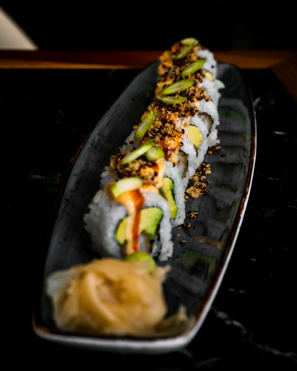 a sushi dish is served on a black plate