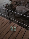 A person wearing slippers stepping out on a morning porch.