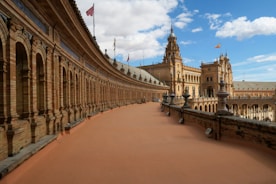 a walkway between two buildings with a clock tower in the background
