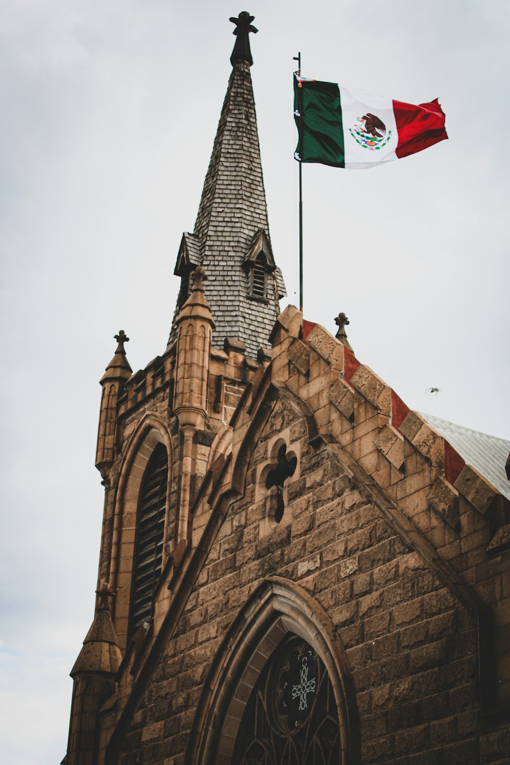 two flags flying in front of an old church