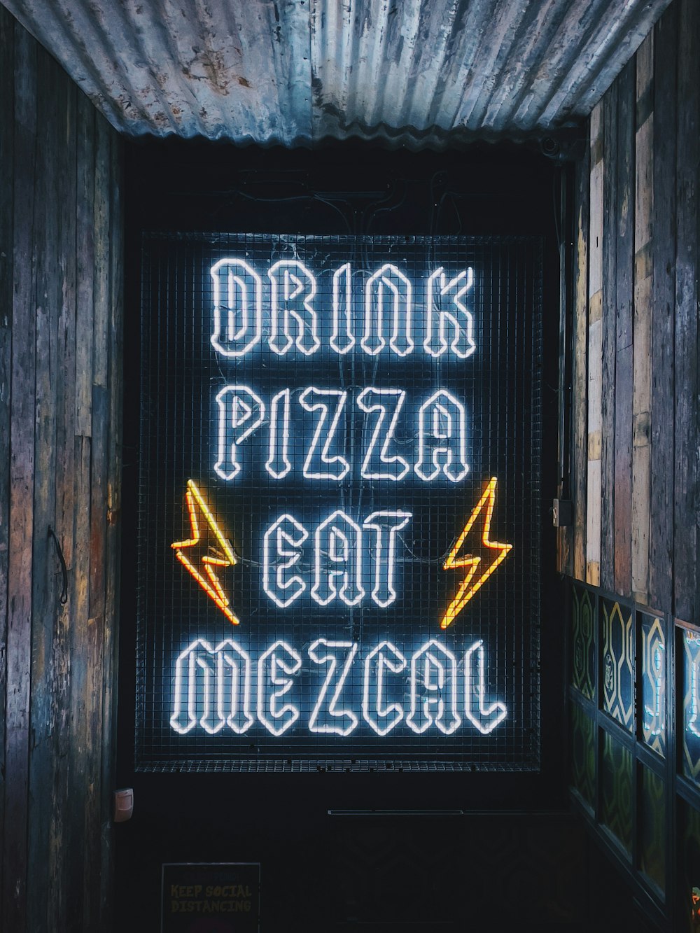 a neon sign that reads drink pizza eat mezza
