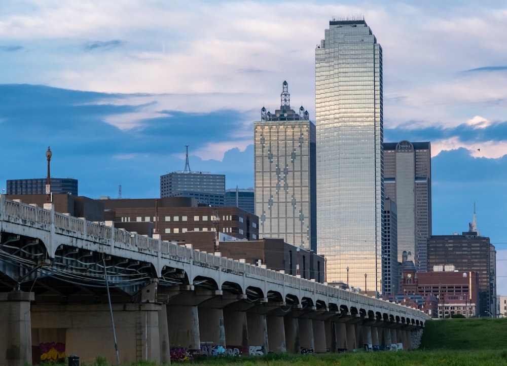 a city skyline with tall buildings and a bridge