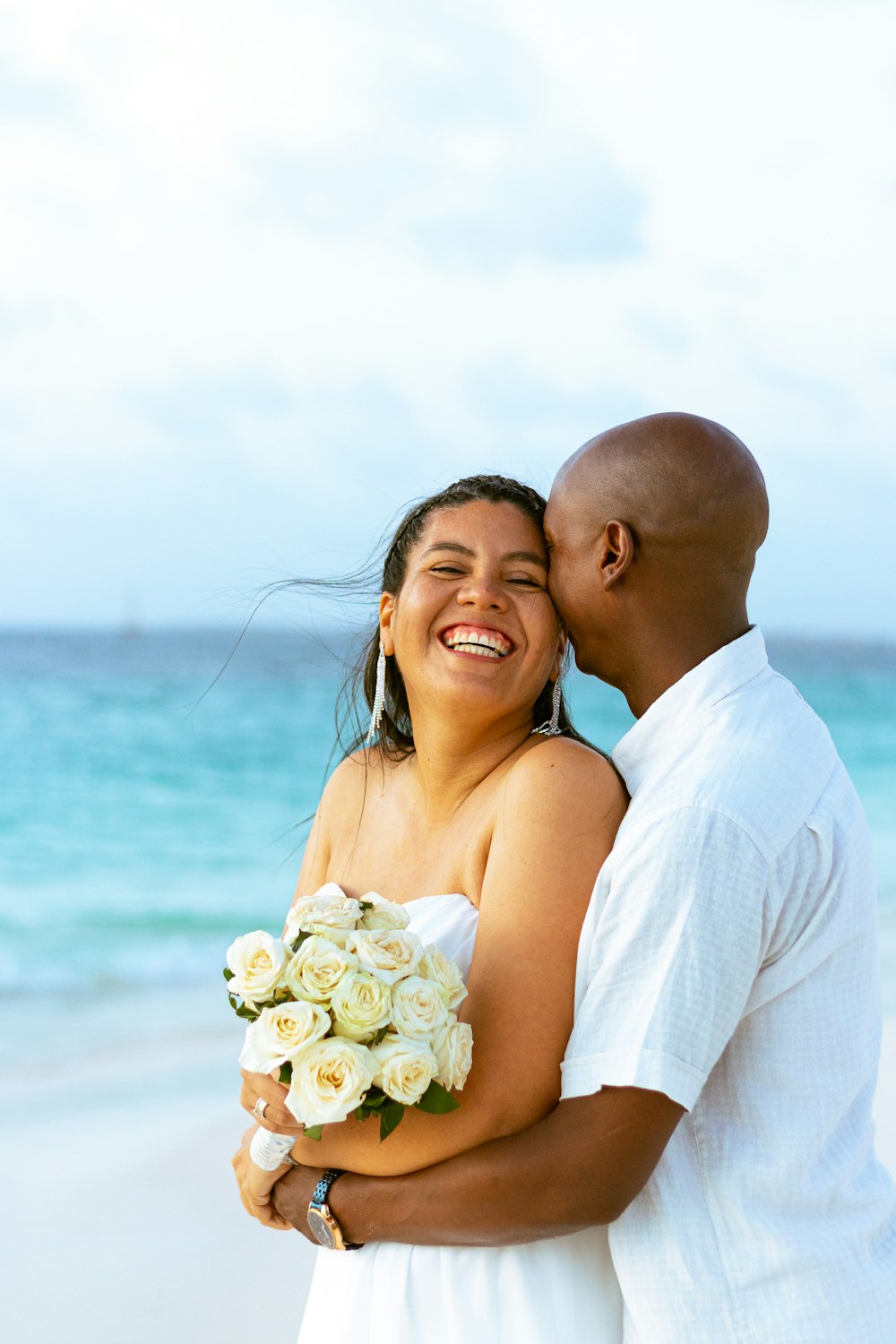 a man and a woman are hugging on the beach