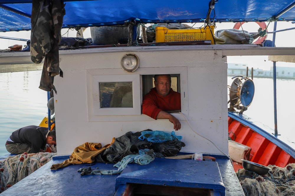 a man looking out of a window on a boat