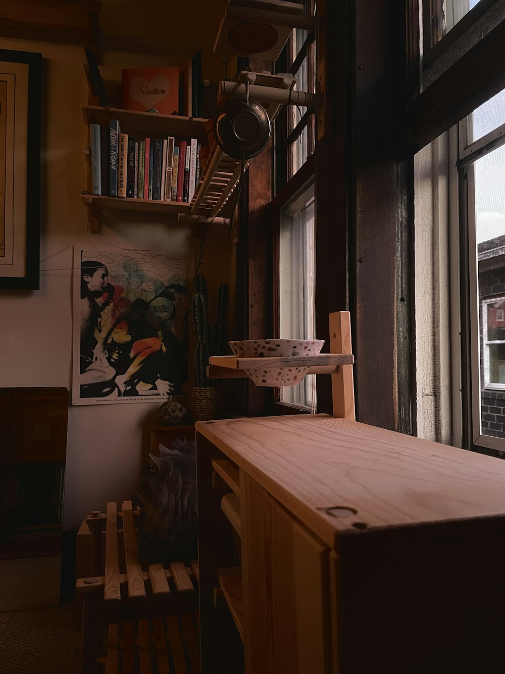 a room with a wooden table and bookshelf