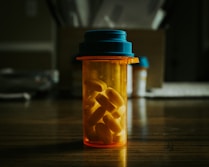 a bottle filled with pills sitting on top of a wooden table