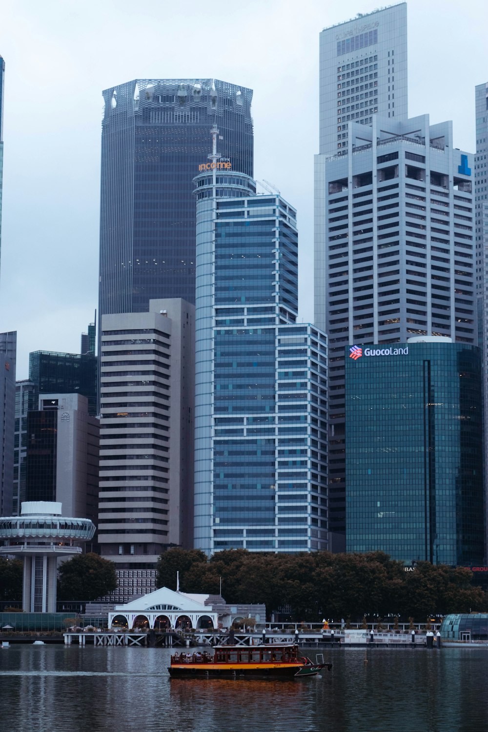 a boat floating in the water in front of tall buildings