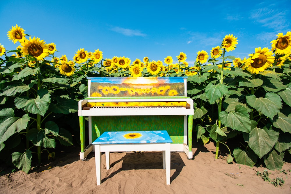 a piano sitting in the middle of a field of sunflowers
