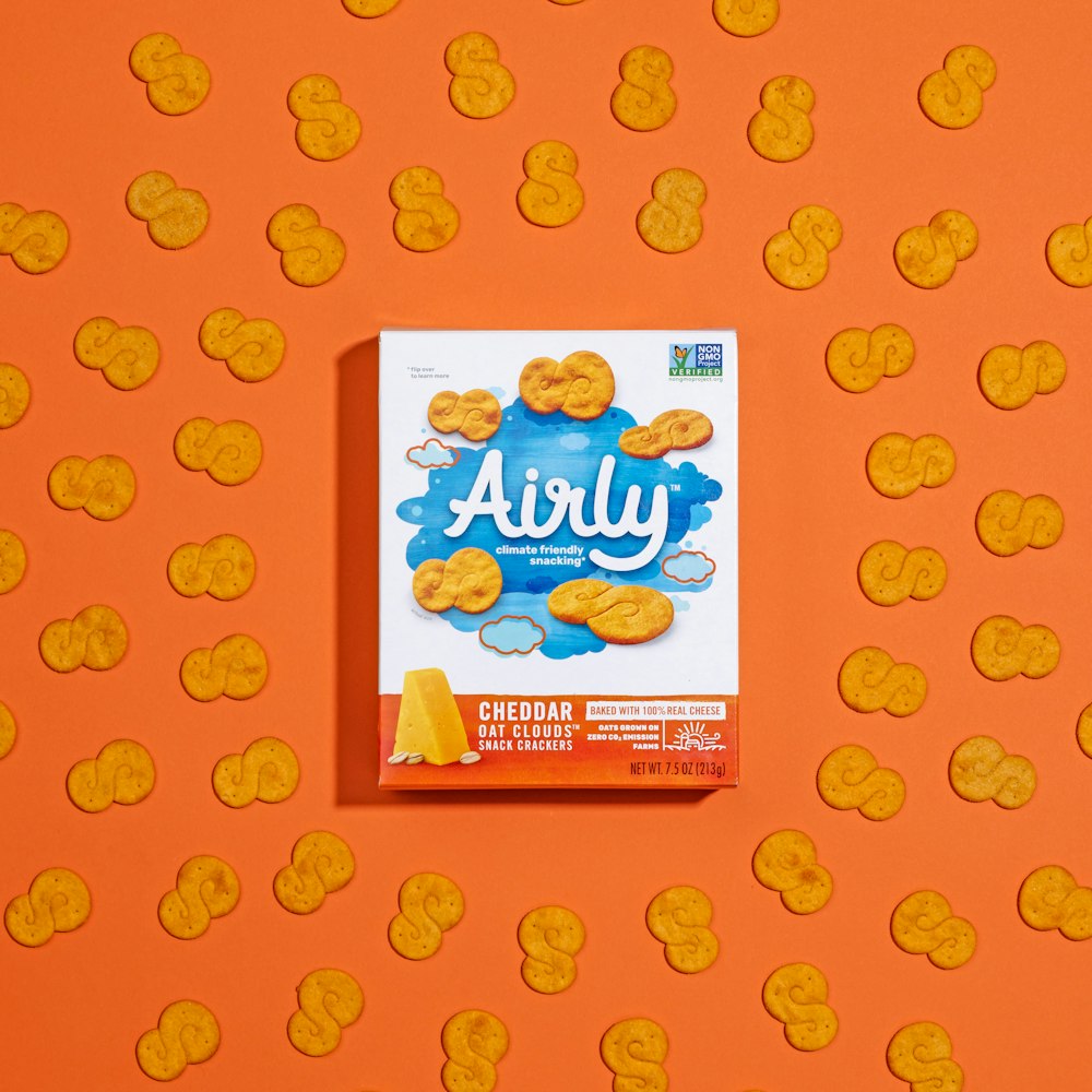 a carton of airly cookies on an orange background