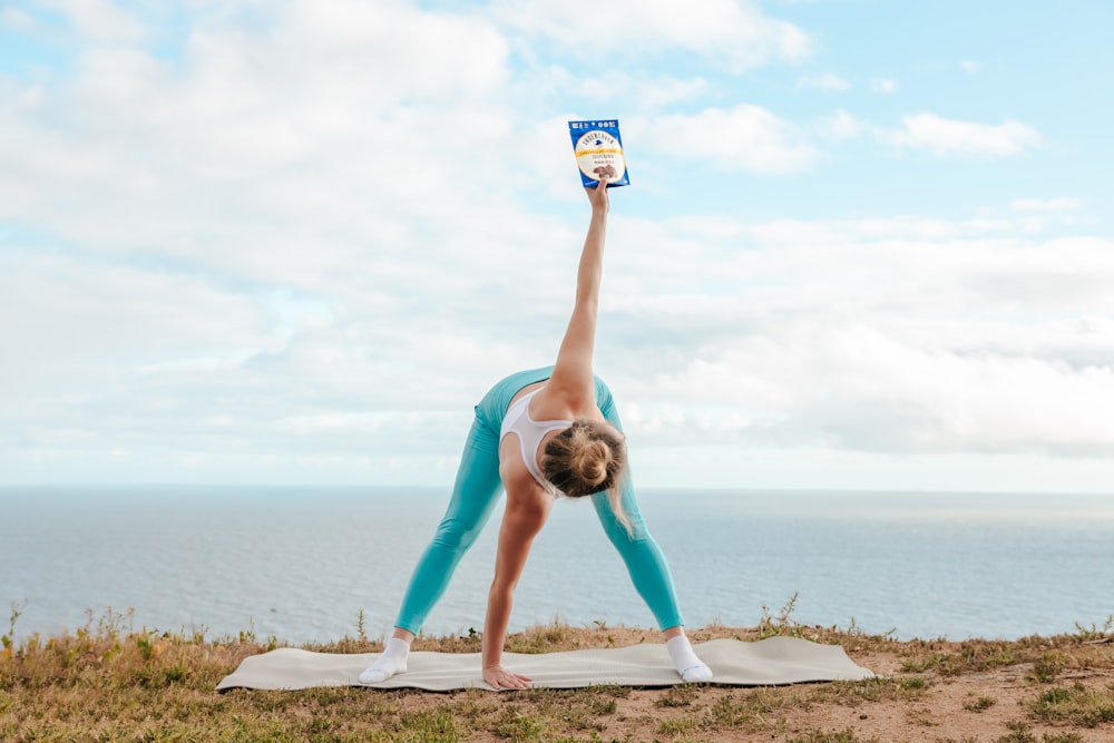 a woman doing a yoga pose on a beach