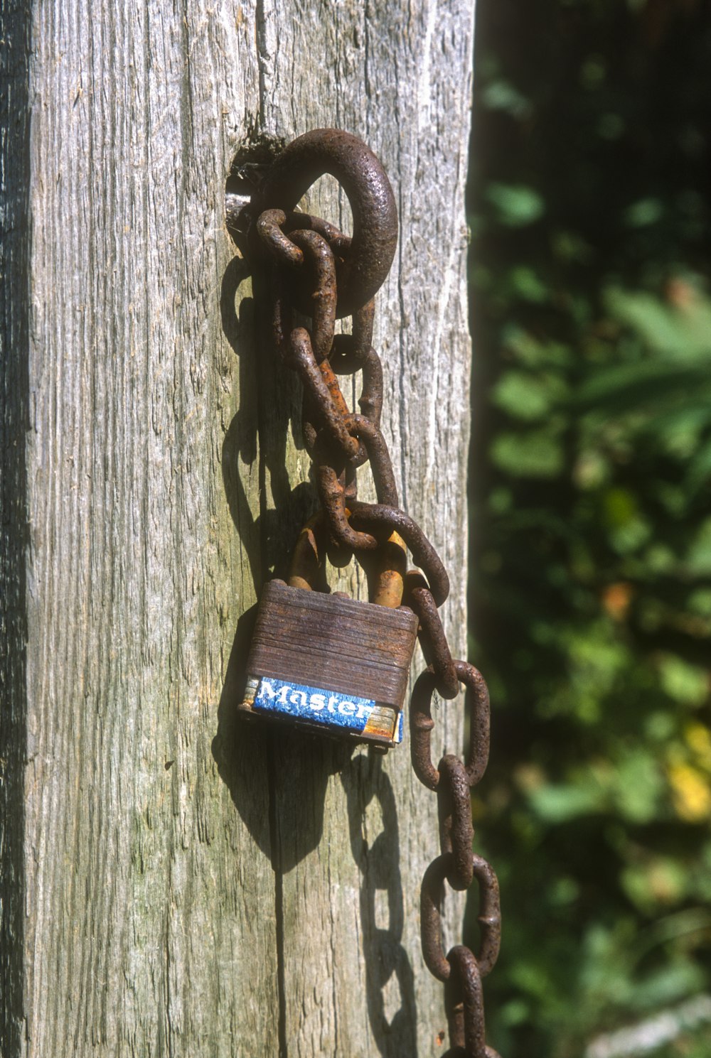 a chain attached to a wooden post with a padlock