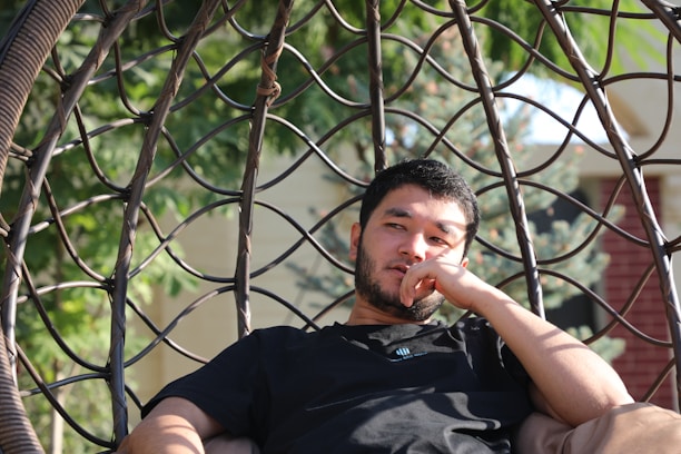 a man sitting in a hammock with his finger in his mouth