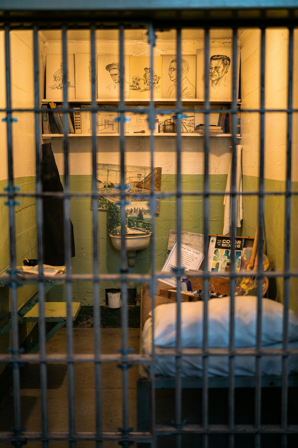 uma cela de prisão com uma cama e um banheiro