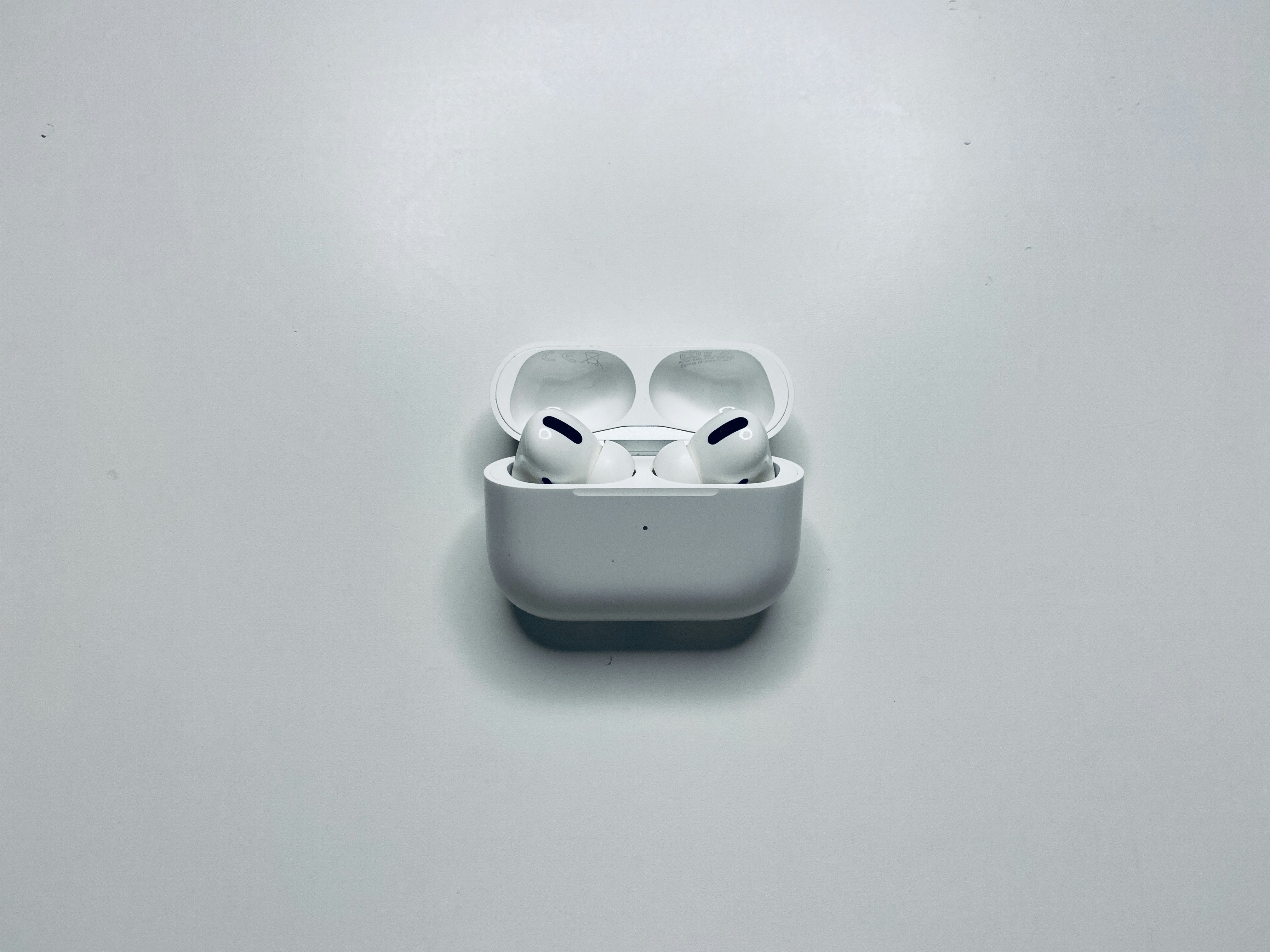 Apple AirPods Pro in white charging case on bright white background